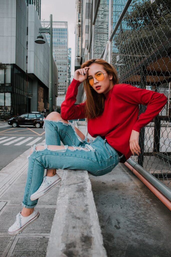 Stylish woman posing in vibrant streetwear in a cityscape setting, exuding confidence.