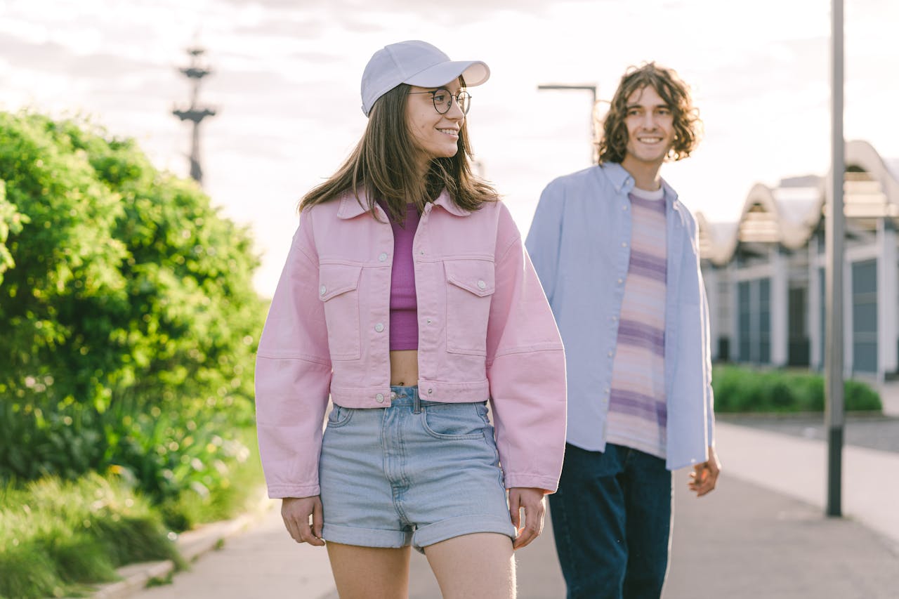 Home Casual young couple walking outdoors in sunny weather, showcasing fashion style.