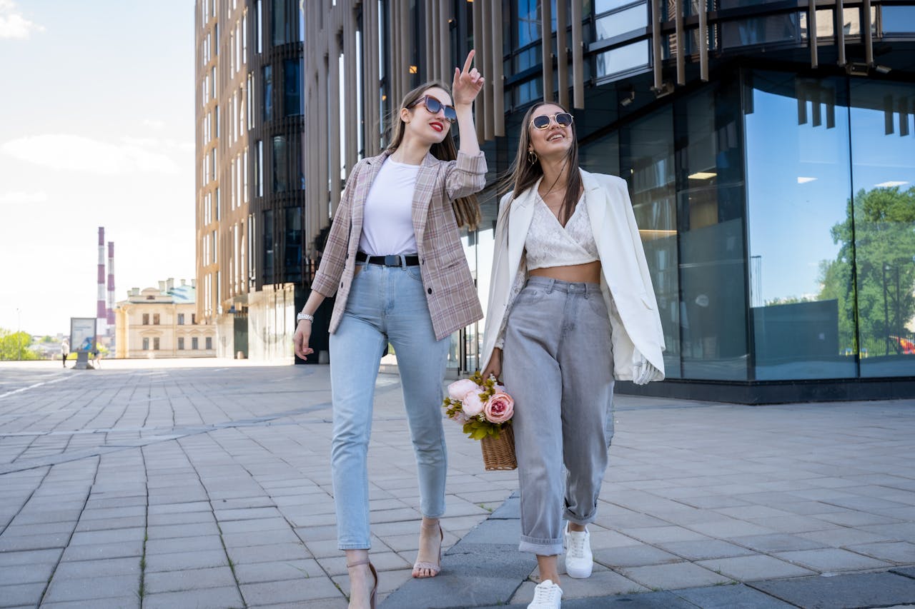 Home Two stylish women in sunglasses walking outdoors, embracing fashion trends.